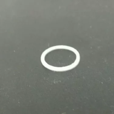 A small, white Isomac 000116 Gasket rests on a dark gray surface; it fits between the steam pipe and steam tip on Isomac TEA, Millennium, or Rituale machines. © 2025 1st-line.com