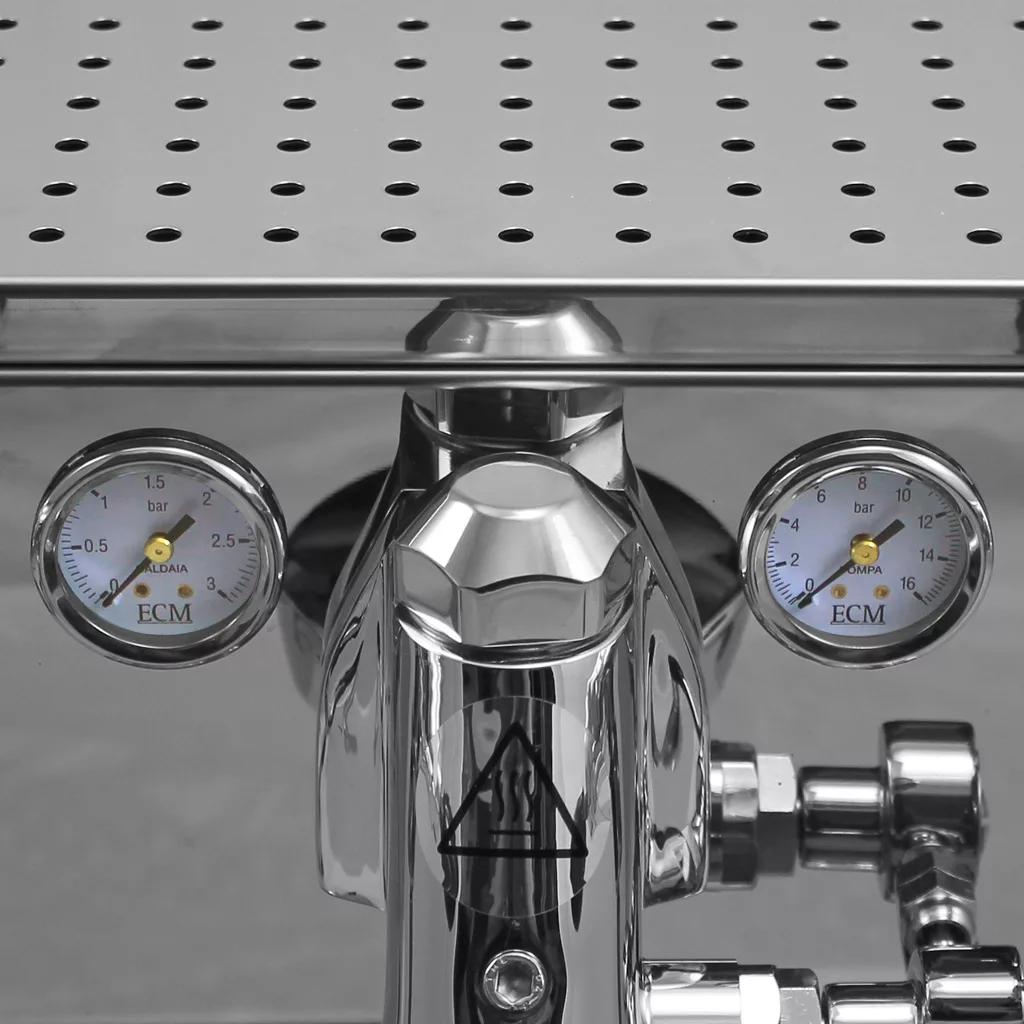 Close-up of a polished DISCONTINUED ECM Technika Profi IV HX Switchable Espresso Machine, featuring two ECM-labeled pressure gauges with needle and bar markings, and a perforated metal tray positioned above the gauges. © 2025 1st-line.com