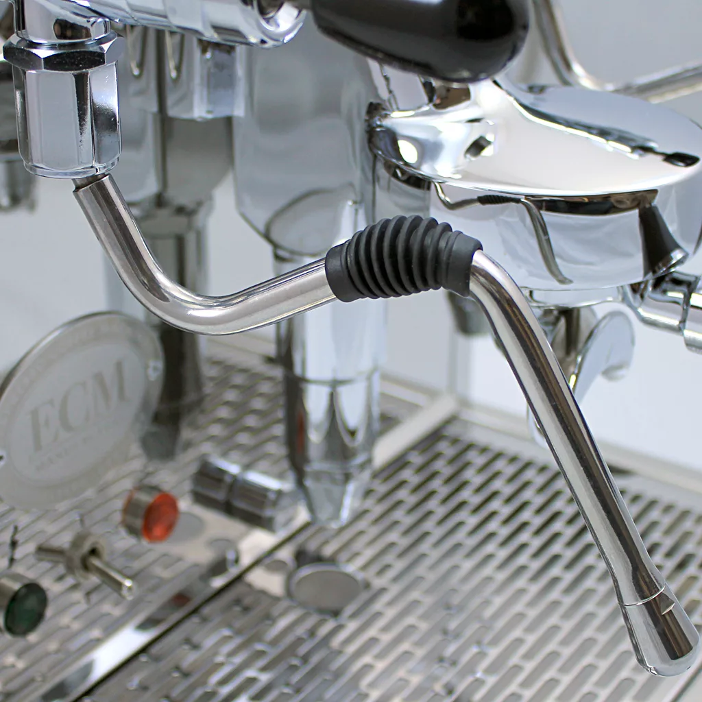 Close-up of the shiny stainless steel DISCONTINUED ECM Technika Profi IV HX Switchable Espresso Machine, highlighting the steam wand with a black rubber grip and the metal grate drip tray below. © 2025 1st-line.com