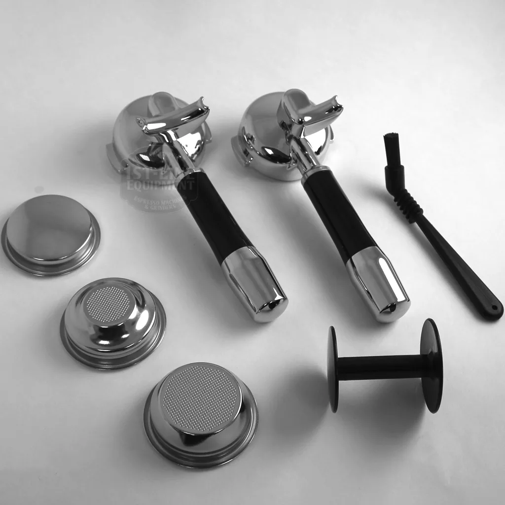 Two espresso portafilters, filter baskets, a black cleaning brush, tamper, and metal filter screens for the DISCONTINUED ECM Technika Profi IV HX Switchable Espresso Machine are arranged on a white background. © 2025 1st-line.com