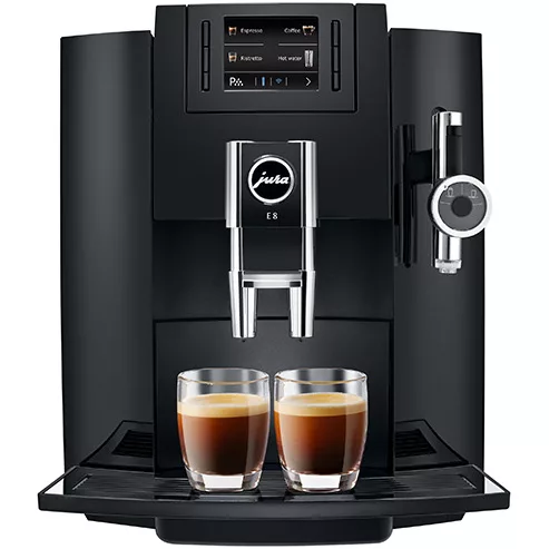 The DISCONTINUED Jura E8 Super-Automatic Coffee Machine in black brews two espressos at once, with clear cups of coffee positioned under the dual spouts on the drip tray. © 2025 1st-line.com