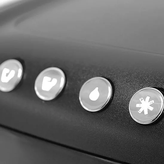Close-up of four round buttons on the black REDIRECTED Ascaso Kap Tronic Capsule Espresso Machine, each featuring a unique illuminated icon: cup, mug, water droplet, and snowflake/star symbol. © 2025 1st-line.com