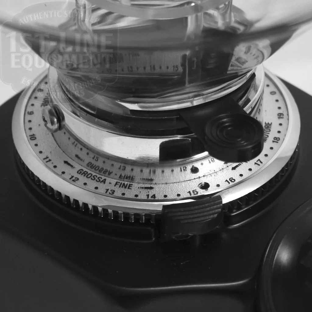 Close-up of the adjustment dial on the DISCONTINUED Quamar M80 Semi-Automatic Doser Espresso Coffee Grinder, labeled Grossa-Fine with black and white numbers and markings for grind size settings. © 2025 1st-line.com