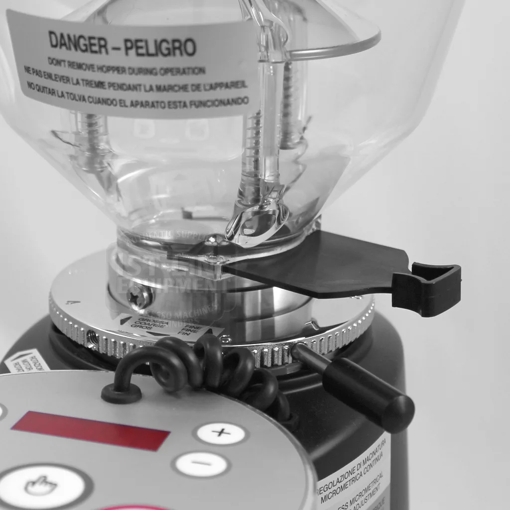 Close-up of the DISCONTINUED Mazzer Mini Type A Espresso Coffee Grinder (old style) showing its clear hopper, warning label, numbered metal adjustment ring, and control panel with buttons and display in sleek black and silver. © 2025 1st-line.com
