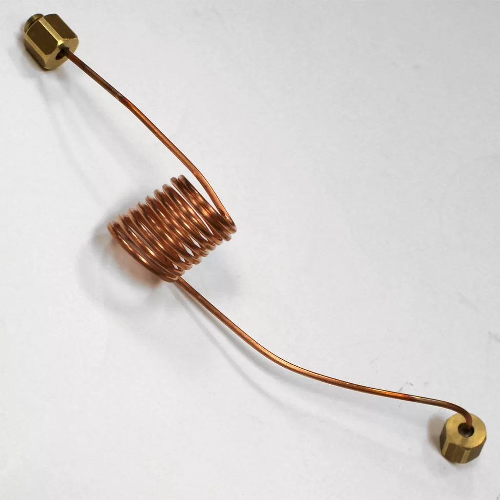 The Lelit MC526 Capillary for Double Manometer, with a central copper tube and brass fittings at each end, lies on a white surface. Its tightly wound copper coil stretches straight out from both sides. © 2025 1st-line.com