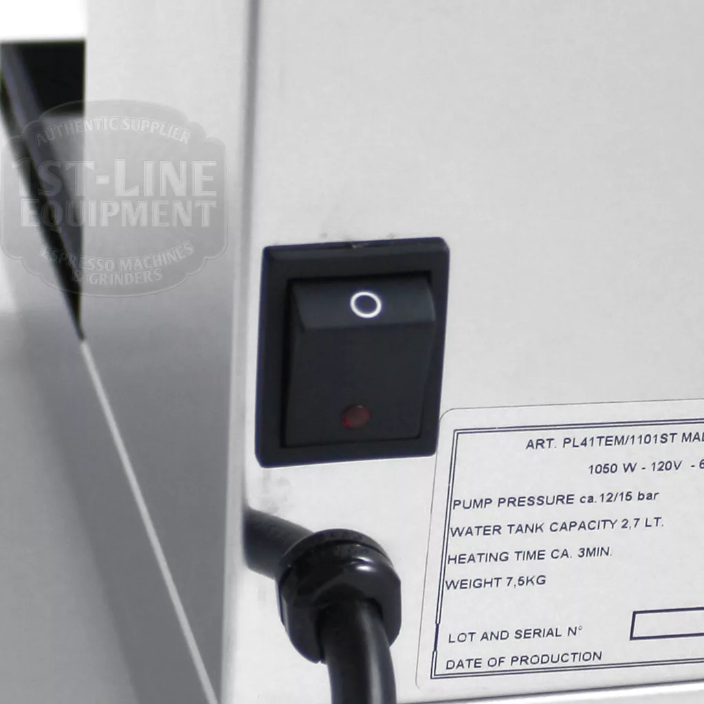 A close-up of a black power switch on the stainless steel Lelit PL41TEM Anna PID Espresso Machine, featuring printed technical specs, a partially visible logo to the left, and a black power cord connected at the bottom. © 2025 1st-line.com