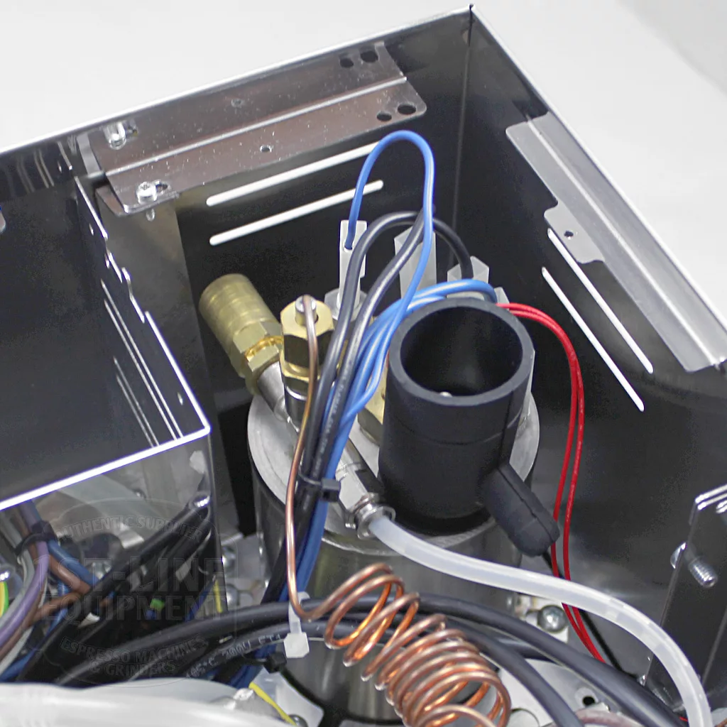 Close-up of internal components inside the DISCONTINUED Lelit PL60PLUST Diana PID Dual Boiler Espresso Machine, showing metal parts, a copper coil, brass valve, and colored wires within its metallic enclosure. © 2025 1st-line.com