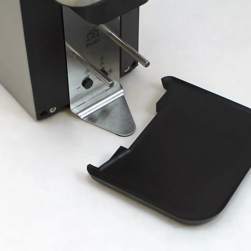 Close-up of the DISCONTINUED Lelit PL71 William Espresso Coffee Grinder with two steel rods, a push button, and a detached black plastic drip tray on a white surface. © 2025 1st-line.com