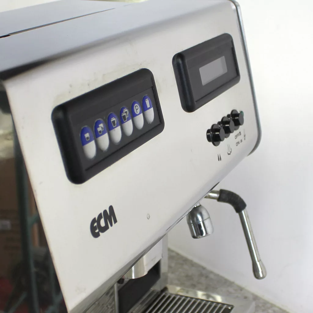 A close-up of the (SOLD) SIDEWALK SALE - ECM Veronica Espresso Machine USED E002 E502, featuring push buttons, a digital display, steam wand, and drip tray on a countertop against a plain background. © 2025 1st-line.com