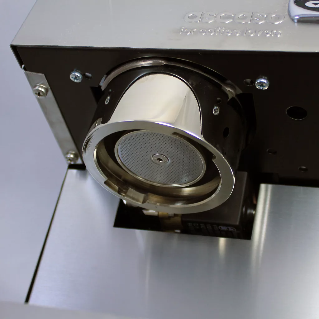 Close-up of the DISCONTINUED Ascaso Steel Uno V4 PID Tank/Reservoir Professional Espresso Machine - boiler, showcasing its shiny metal portafilter holder, fine mesh filter, and partially visible ASCASO branding. © 2025 1st-line.com