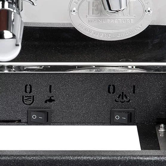 Close-up of the control panel on the DISCONTINUED ECM Synchronika Dual Boiler Espresso Machine, highlighting two switches, cup and steam wand icons, part of the chrome portafilter, and the ECM logo plate above. © 2025 1st-line.com