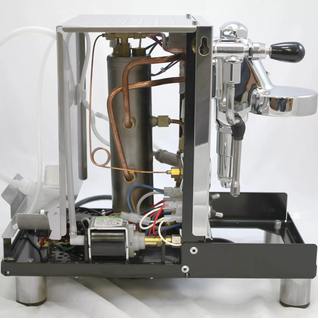 A partially disassembled Bezzera Unica Espresso Machine displays its inner components—copper pipes, a boiler, wiring, and metal parts—set against a plain white background. © 2025 1st-line.com