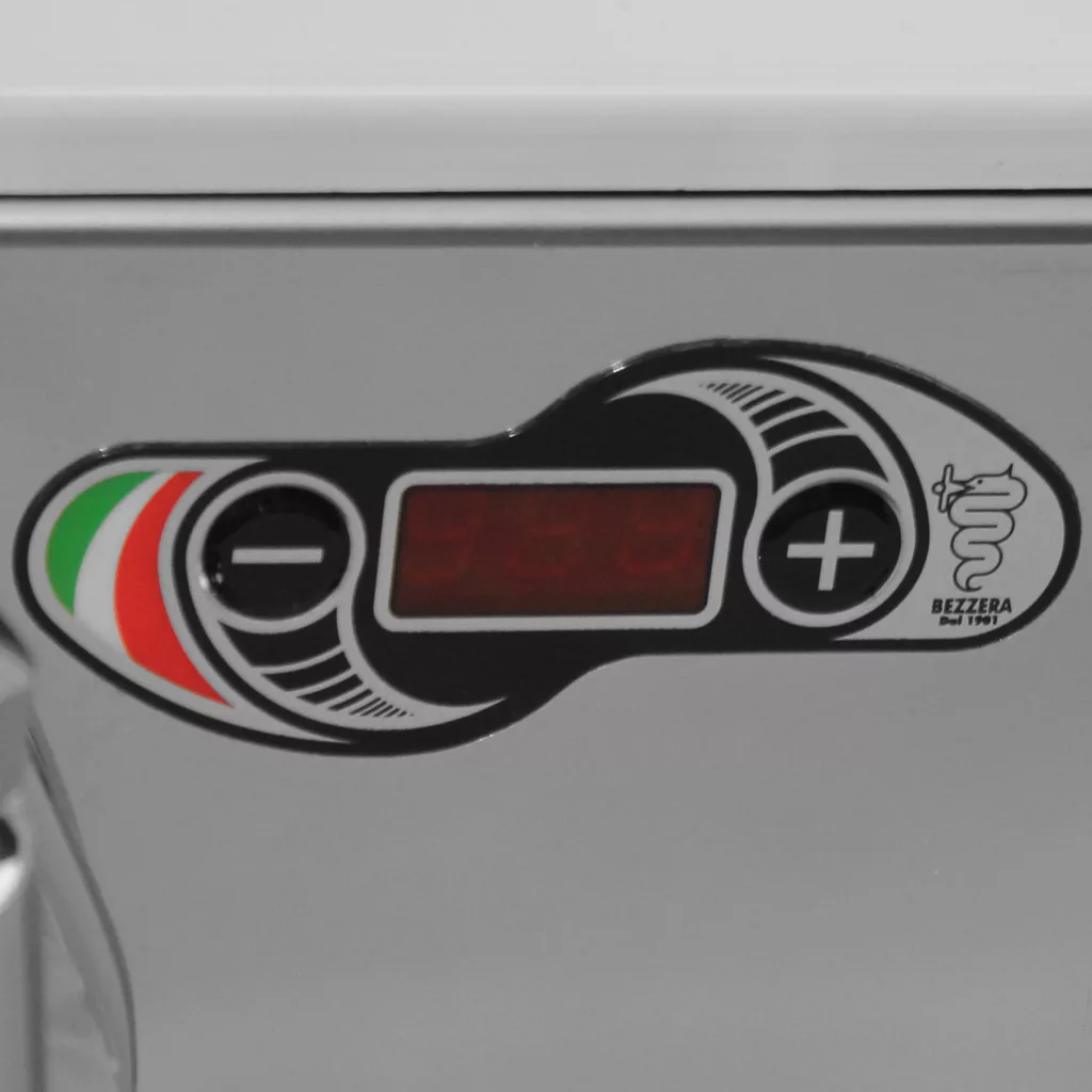 Close-up of the Bezzera Unica Espresso Machine control panel showing plus/minus buttons, an empty red digital display, an Italian flag motif, and the Bezzera logo with a snake and cup. © 2025 1st-line.com