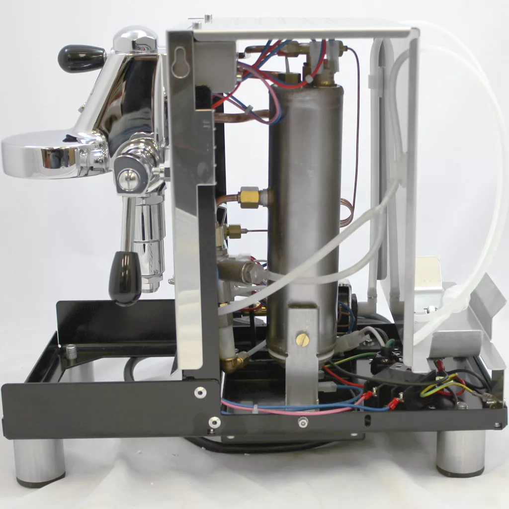 Side view of a partially disassembled Bezzera Unica Espresso Machine with the exterior casing removed, revealing internal components, tubing, wiring, and metal parts. © 2025 1st-line.com