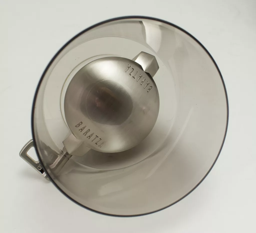 Top-down view of a transparent gray plastic hopper with metal base, labeled BARATZA and VIRTUOSO, on white background—ideal for setups featuring the Baratza Vario W Weight Based Coffee Grinder. © 2025 1st-line.com