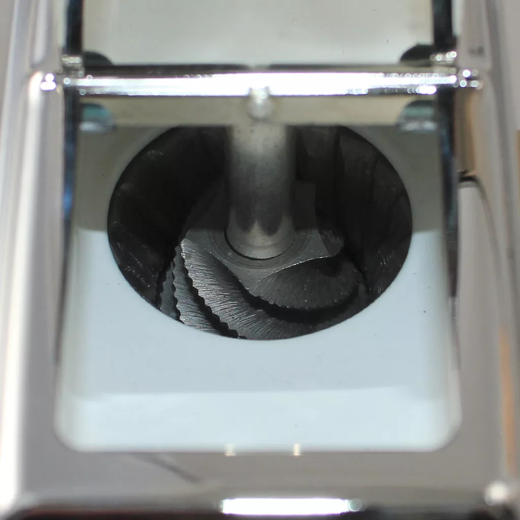 Close-up of the sharp burr grinding mechanism inside a metal coffee grinder, seen through the top opening—similar to the DISCONTINUED Zassenhaus Santiago Hand Coffee Grinder / Coffee Mill - varnished beech. © 2025 1st-line.com