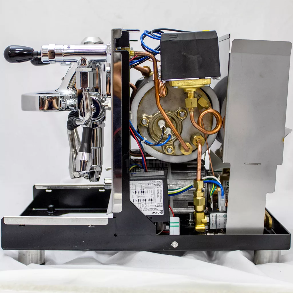 A side view of the DISCONTINUED ECM Mechanika Profi IV Switchable Espresso Machine with its side panel removed, showing wires, pipes, a boiler, and other internal metal and electronic components. © 2025 1st-line.com