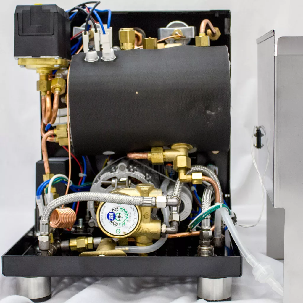 The image displays the internal components of the DISCONTINUED ECM Mechanika Profi IV Switchable Espresso Machine, revealing metal pipes, wires, a black cylindrical boiler, and brass fittings with its side panel removed. © 2025 1st-line.com