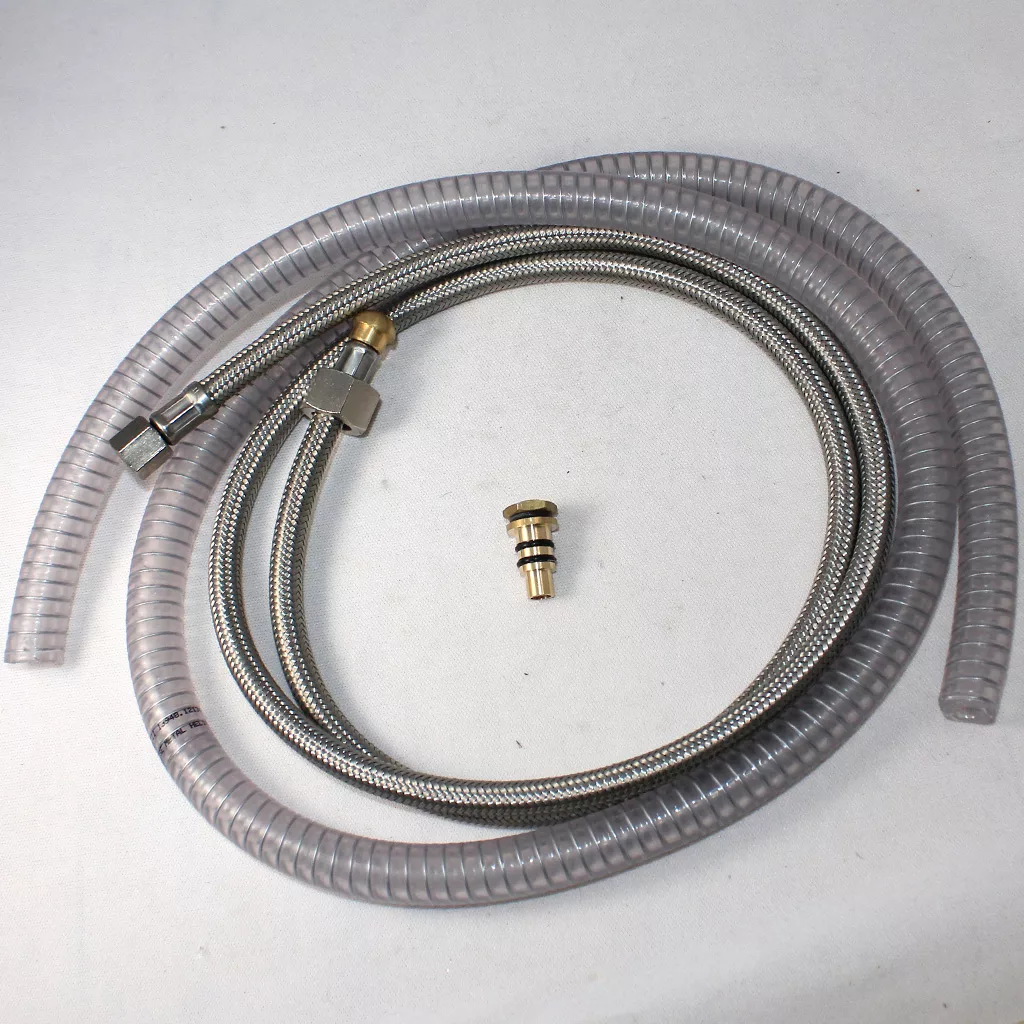 On a white surface are a coiled metal hose with fittings, transparent cover, and brass connector—ideal accessories for your DISCONTINUED VBM Domobar Super V4 Dual Boiler PID Switchable Espresso Machine. © 2025 1st-line.com