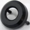 A black, circular plastic Saeco Water seal cap - Royal with a central hole and two short pegs on the back is shown resting on a light gray textured surface. © 2025 1st-line.com