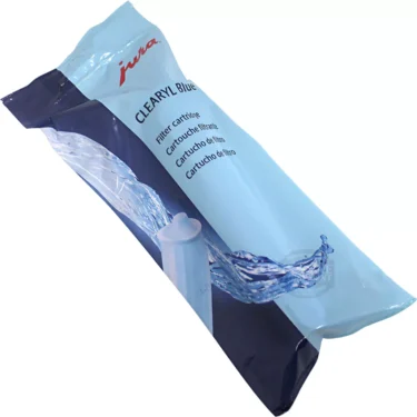 A blue and white sealed package labeled Jura 71445 CLEARYL Blue Water Filter, featuring a splash of water around the filter cartridge. © 2025 1st-line.com