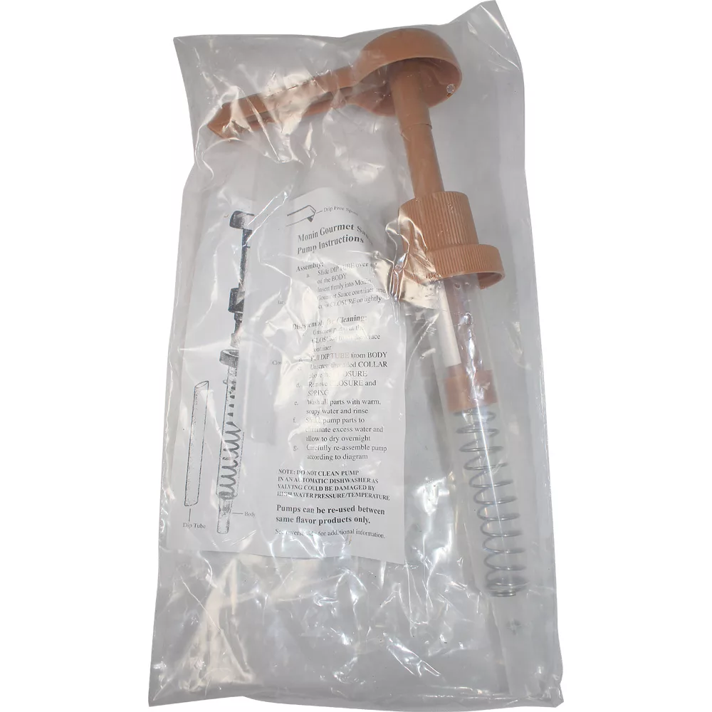 A brown plastic Monin Pump - sugar free dark chocolate with a coiled metal spring is packaged in a clear plastic bag, printed instructions visible behind the pump. © 2025 1st-line.com