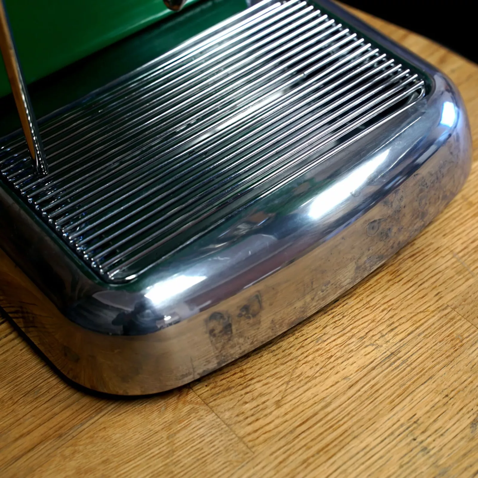A close-up of a used Ascaso Dream V1 UP Meadow Green Espresso Machine tank/reservoir on a wooden countertop, with reflections visible on the stainless steel. © 2025 1st-line.com