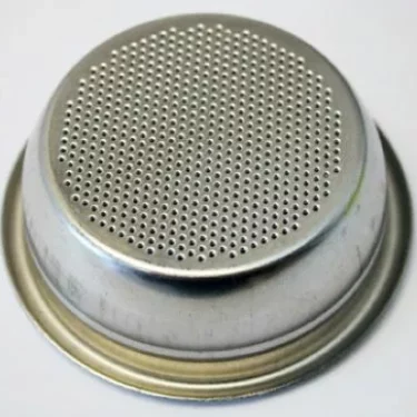A close-up of the Grimac GR765 2-Cup Filter Basket/Cup with Rim 14g for Zola & MiniGrimac, featuring numerous small holes on its flat metal surface, designed to hold coffee grounds during brewing. © 2025 1st-line.com
