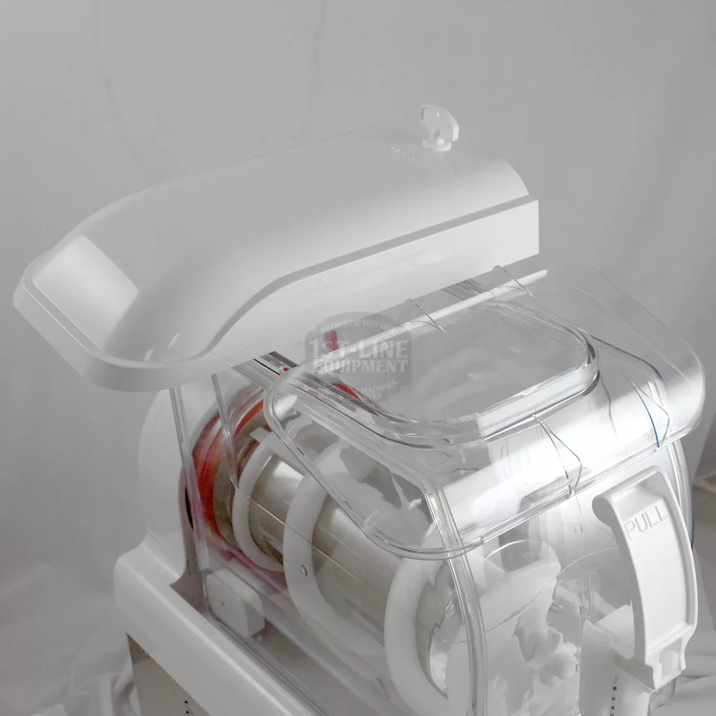 A close-up of the IN STORE PICKUP ONLY - SPM SP1 Commercial Frozen Beverage Dispenser (1 bowl, white) with a partially open lid showing cylindrical components and the word “PULL” on the transparent cover. © 2025 1st-line.com