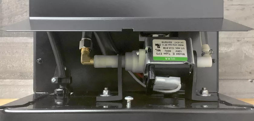 A close-up of the Rancilio Silvia M Espresso Machine’s interior shows wiring, an “ULKA Model E Type EP5” motor, pipes, and metal parts inside a black metal casing. © 2025 1st-line.com