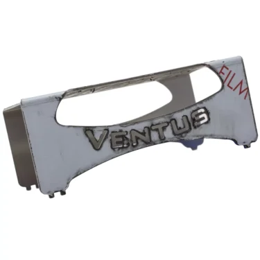 A metallic ACS VEN0038 Drip Tray Stand / Extension labeled VENTUS shows cut-out sections and visible wear, with partial red FILM text on the top right. The object has an industrial, machined look. © 2025 1st-line.com