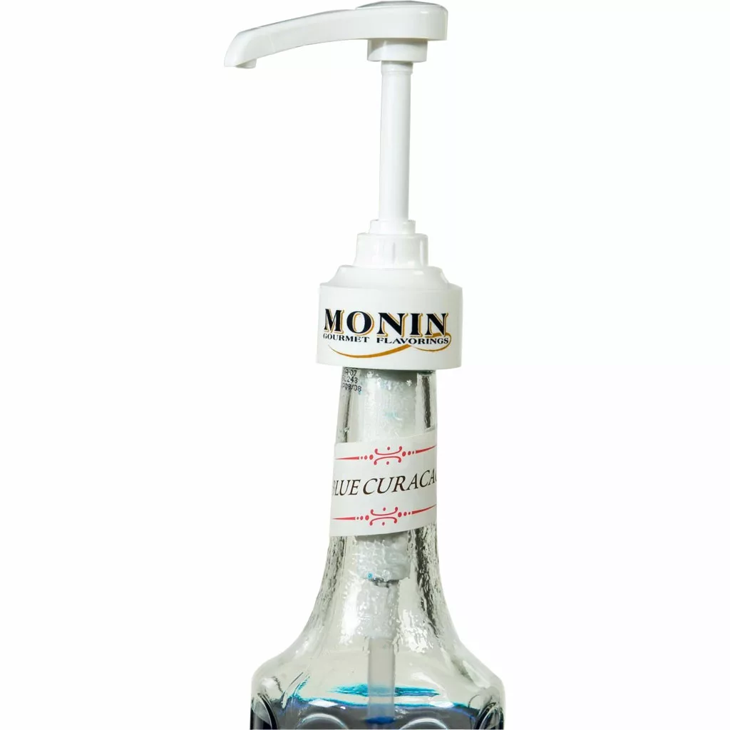 A Monin Glass Bottle Pump (Monin logo) is attached to a Monin syrup bottle labeled MONIN Gourmet Flavorings, with part of the BLUE CURAÇAO label visible. © 2025 1st-line.com
