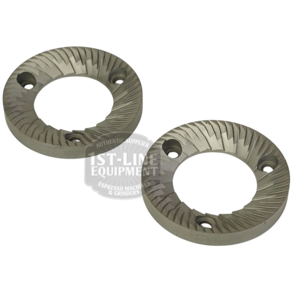 A set of two Mazzer FMA00182D/QQQ 1-phase 58mm flat grinding burrs, each with angled teeth and three screw holes, is shown on a white background. © 2025 1st-line.com