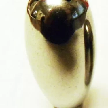 A shiny, metallic, oval-shaped object with four small holes on top—resembling a stylized bird and upright on a white background—is an Elektra 03920015 Steam Wand Tip (4 hole) for Kappa & Aletta only. © 2025 1st-line.com