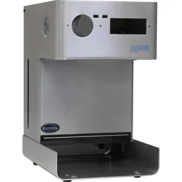 A silver, box-shaped Nemox 619918 Housing with a front panel labeled JUNIOR and a spacious cup tray. The modern industrial design displays the Nemox brand, blending style and function. © 2025 1st-line.com