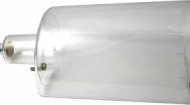 A transparent Elektra 02510034 Water Reservoir for NIVOLA, resembling a glass bell jar with a small opening and metal parts at one end, lies on its side; it is often used in scientific experiments. © 2025 1st-line.com