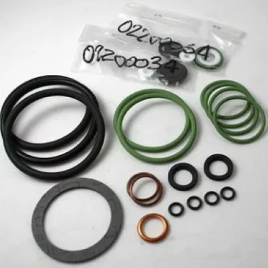 A variety of rubber and metal O-rings, gaskets, and seals from the Elektra 03085034 Gasket Kit for Verticale 2 GR 98 are displayed on a white surface, with some in labeled plastic bags in the background. © 2025 1st-line.com