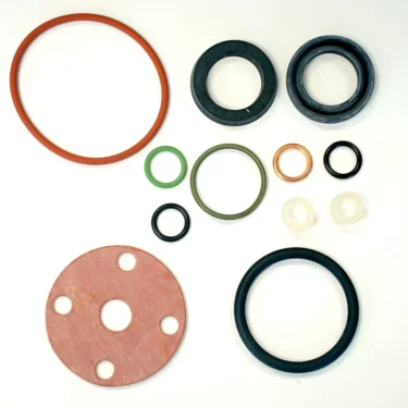 Assorted gaskets, O-rings, washers, and seals from the Elektra 01930034 Gasket Kit in various sizes, shapes, and colors are arranged neatly on a white background. © 2025 1st-line.com