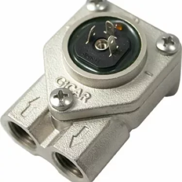 Close-up of a metallic Fiorenzato A1500026 Volumetric Counter featuring two input/output ports, arrow indicators, and exposed top electrical connectors secured by two screws. © 2025 1st-line.com