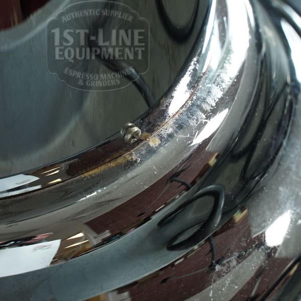 Close-up of a shiny Elektra Mini Verticale A1C Espresso Machine (Chrome) part with a small rust spot and a faint logo—ideal for espresso enthusiasts or Sidewalk Sale shoppers. © 2025 1st-line.com