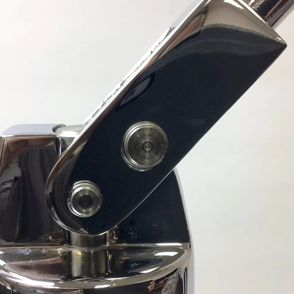 Close-up of a shiny hinge mechanism with visible screws on a polished espresso machine, reflecting high-quality craftsmanship reminiscent of the DISCONTINUED Ponte Vecchio Lusso 1 Group Spring Piston Lever Espresso Machine. © 2025 1st-line.com