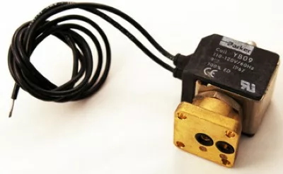 Close-up of a VBM UNK61559532 3-Way Solenoid Valve with a black coil, electrical wires, and a rectangular brass base featuring two circular openings. © 2025 1st-line.com