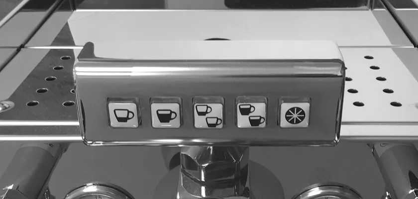 Close-up of the DISCONTINUED ECM Elektronika II Profi HX Espresso Machine’s control panel, featuring five cup and starburst buttons on a reflective metal surface designed for selecting coffee options. © 2025 1st-line.com
