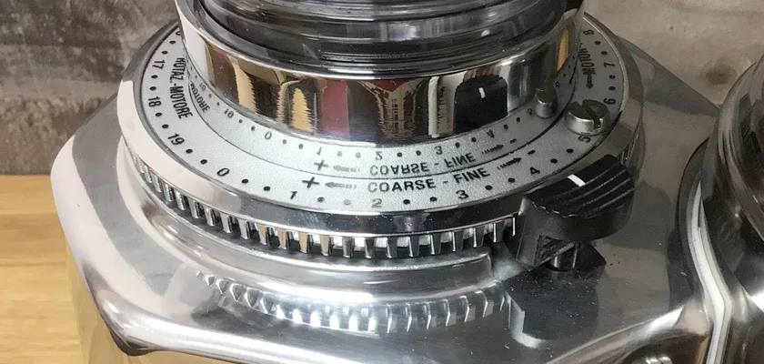 Close-up of the DISCONTINUED Quamar M80E V2 On Demand Espresso Coffee Grinder, featuring a grooved dial with numbered coarse-to-fine grind settings and adjustment notches—perfect for on-demand grinding. © 2025 1st-line.com