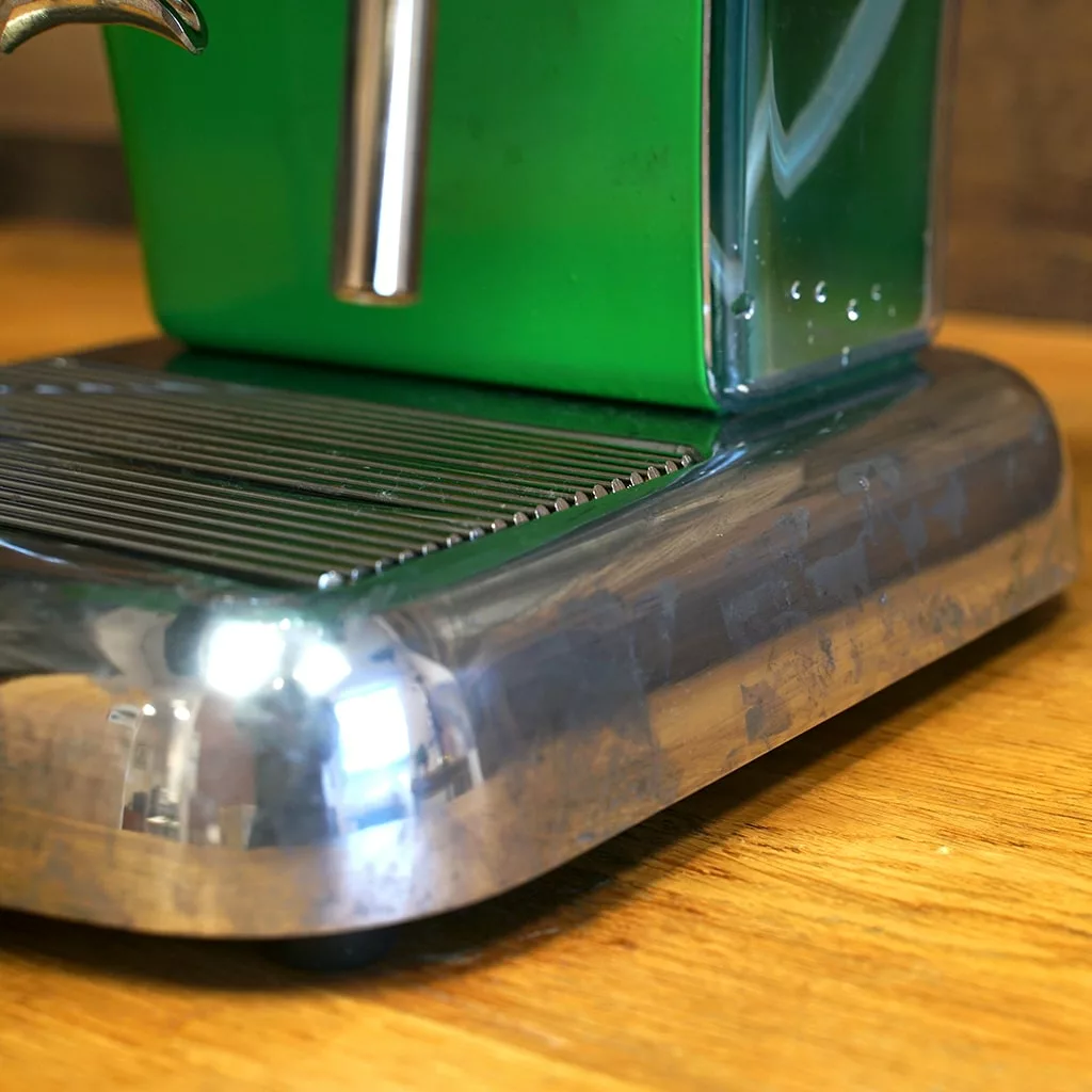 Close-up of the drip tray and base of a used (SOLD) SIDEWALK SALE - Ascaso Dream V1 UP Meadow Green Espresso Machine Tank/Reservoir on a wooden countertop. © 2025 1st-line.com