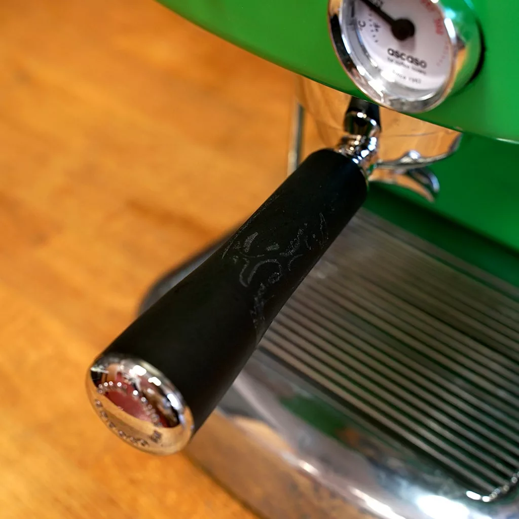 Close-up of the (SOLD) SIDEWALK SALE - Ascaso Dream V1 UP Meadow Green Espresso Machine with tank/reservoir, pressure gauge, and metal drip tray on a wooden countertop. Lightly used and in excellent condition. © 2025 1st-line.com