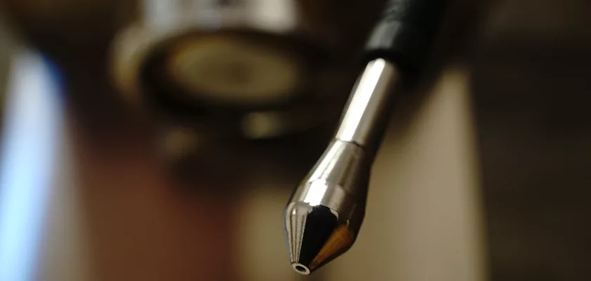 Close-up view of a metallic waterjet cutter nozzle with blurred background, highlighting the precision tip—akin to the craftsmanship of the DISCONTINUED Lelit Victoria PL91T PID Single Boiler Espresso Machine. © 2025 1st-line.com