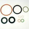 Elektra 03156034 Gasket Kit O-rings and washers in assorted sizes and colors—orange, black, green, copper, and white—are displayed on a white background. © 2025 1st-line.com