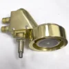 The Elektra 02286038 Brass Complete Assembly Grouphead Delivery Unit features three pipe connections and a large, round, gold-colored control knob, shown resting on a white surface. © 2025 1st-line.com