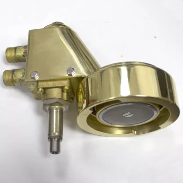 The Elektra 02286038 Brass Complete Assembly Grouphead Delivery Unit features three pipe connections and a large, round, gold-colored control knob, shown resting on a white surface. © 2025 1st-line.com